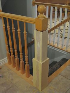 a wooden banister next to a tiled floor