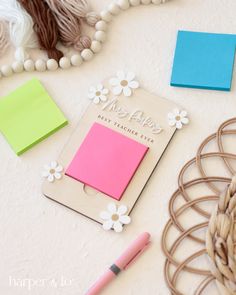 a table topped with assorted items such as notebooks and pens, beads and paper