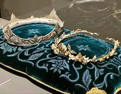 two tiaras sitting on top of a velvet pillow in the shape of a crown