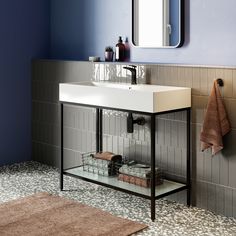 a white sink sitting under a bathroom mirror next to a counter top with a towel on it