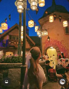 a woman is walking down the street in front of some lights