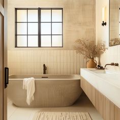 a bathroom with a bathtub, sink and mirror