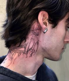 a man with a tattoo on his neck and behind the ear is looking at something