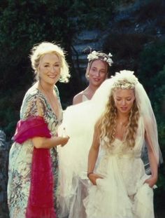 three women in wedding dresses standing next to each other and one is wearing a veil