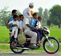 a group of people riding on the back of a motorcycle with two boys and an adult