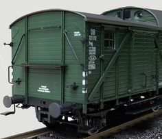 a green train car sitting on the tracks