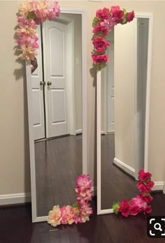 two mirrors with flowers on them in a room