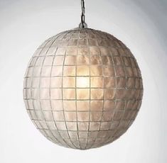 a light that is hanging from a chain on a wall with a ball shaped object in the middle