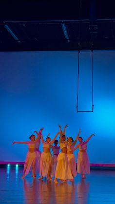 a group of people standing on top of a stage in front of a blue wall