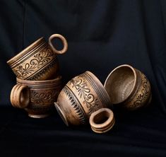 three brown vases sitting next to each other on a black background