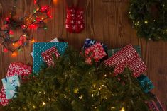 presents wrapped in red, white and blue paper on a wooden table with christmas lights