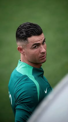 a man in a green shirt looking off into the distance with his head tilted back