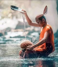 a man is sitting in the water holding a metal bowl