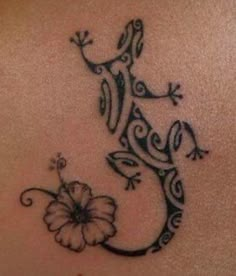 a gecko tattoo on the back of a woman's stomach, with a flower