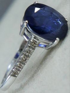 a ring with a large blue stone surrounded by small white diamonds on top of it