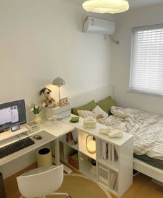 a bedroom with a bed, desk and computer