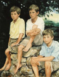 three young boys sitting on top of a rock wall