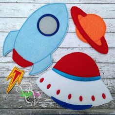 two felt rockets and a rocket ship on a wooden background