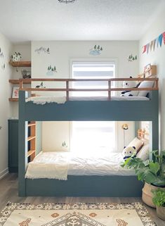 there is a bunk bed in the corner of this room with plants on the floor