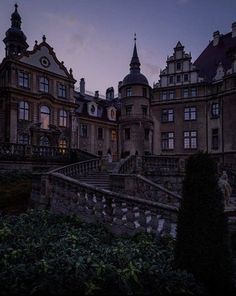 an old building with many windows and balconies on the top floor is lit up at night