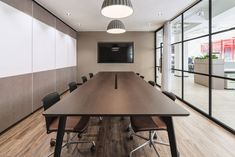 an empty conference room with chairs and a flat screen tv mounted to the wall above it