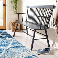 a wooden bench sitting on top of a blue rug next to a door and window