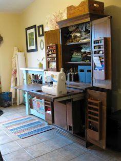 a sewing machine sitting on top of a wooden cabinet next to a rug in a room