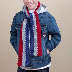 a young boy wearing a red, white and blue crochet scarf with a denim jacket