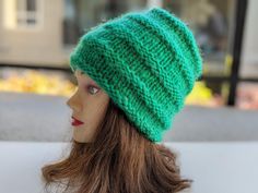 a mannequin head wearing a green knitted hat