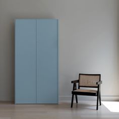 a chair sitting in front of a blue cabinet