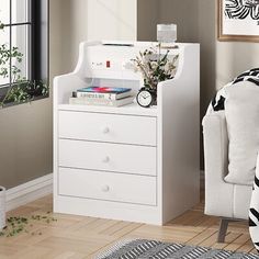 a room with a white chair and some plants on the table next to a window