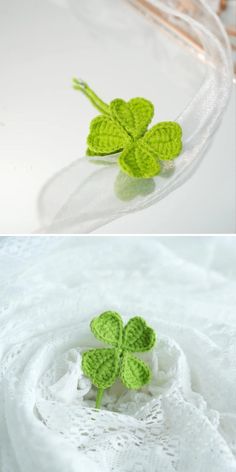 four leaf clovers are placed in a glass bowl on a white surface and the other is made from crocheted yarn