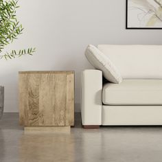 a white couch sitting next to a wooden side table