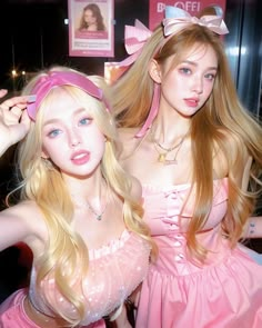 two barbie dolls dressed in pink posing for the camera