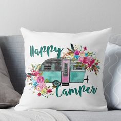 the happy camper throw pillow is sitting on a couch