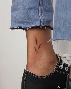 a woman's foot with a small flower tattoo on the side of her leg