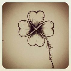 a four - leaf clover is drawn in black ink on a white paper with a brown background