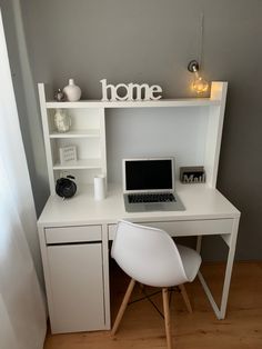 a white desk with a laptop on top of it next to a chair and shelf