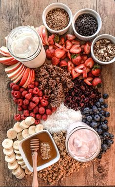 a wooden table topped with lots of fruit and dips