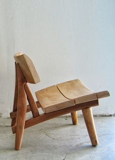 a wooden chair sitting on top of a white floor next to a wall and window