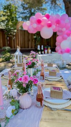 a table set for a party with pink and white balloons