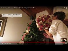 a man is decorating a christmas tree with red and gold bows on it's head