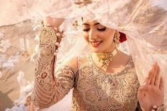 a woman in a bridal gown holding her hands up