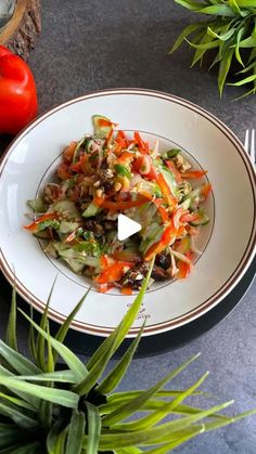 a white plate topped with salad next to two tomatoes