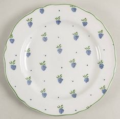 a white plate with blue and green pineapples on the rim, sitting on a table