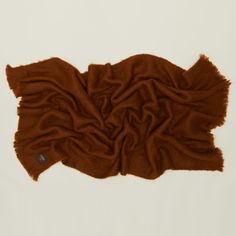 a brown blanket laying on top of a white floor