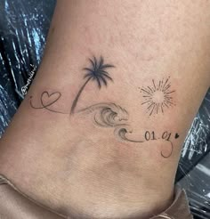 a woman's foot with a palm tree and wave tattoo on the side of her leg