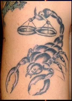 a tattoo on the arm of a man with a crab and scales in it's claws