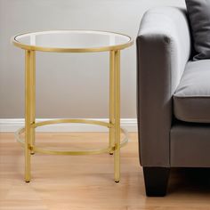 a glass table sitting next to a couch on top of a hard wood floored floor