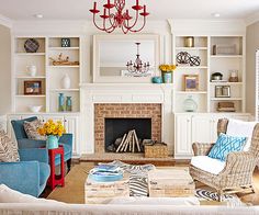 a living room filled with furniture and a fire place under a chandelier in front of a fireplace